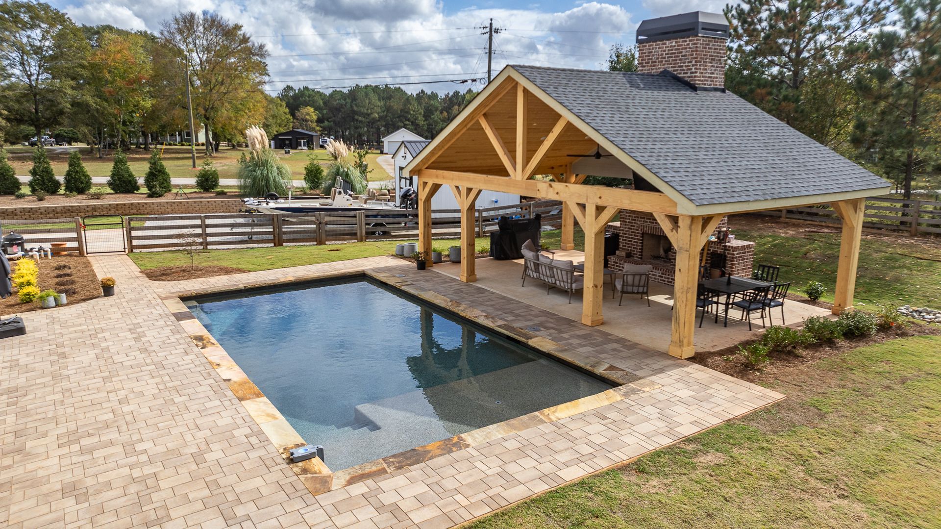 A large swimming pool with a pavilion in the backyard.