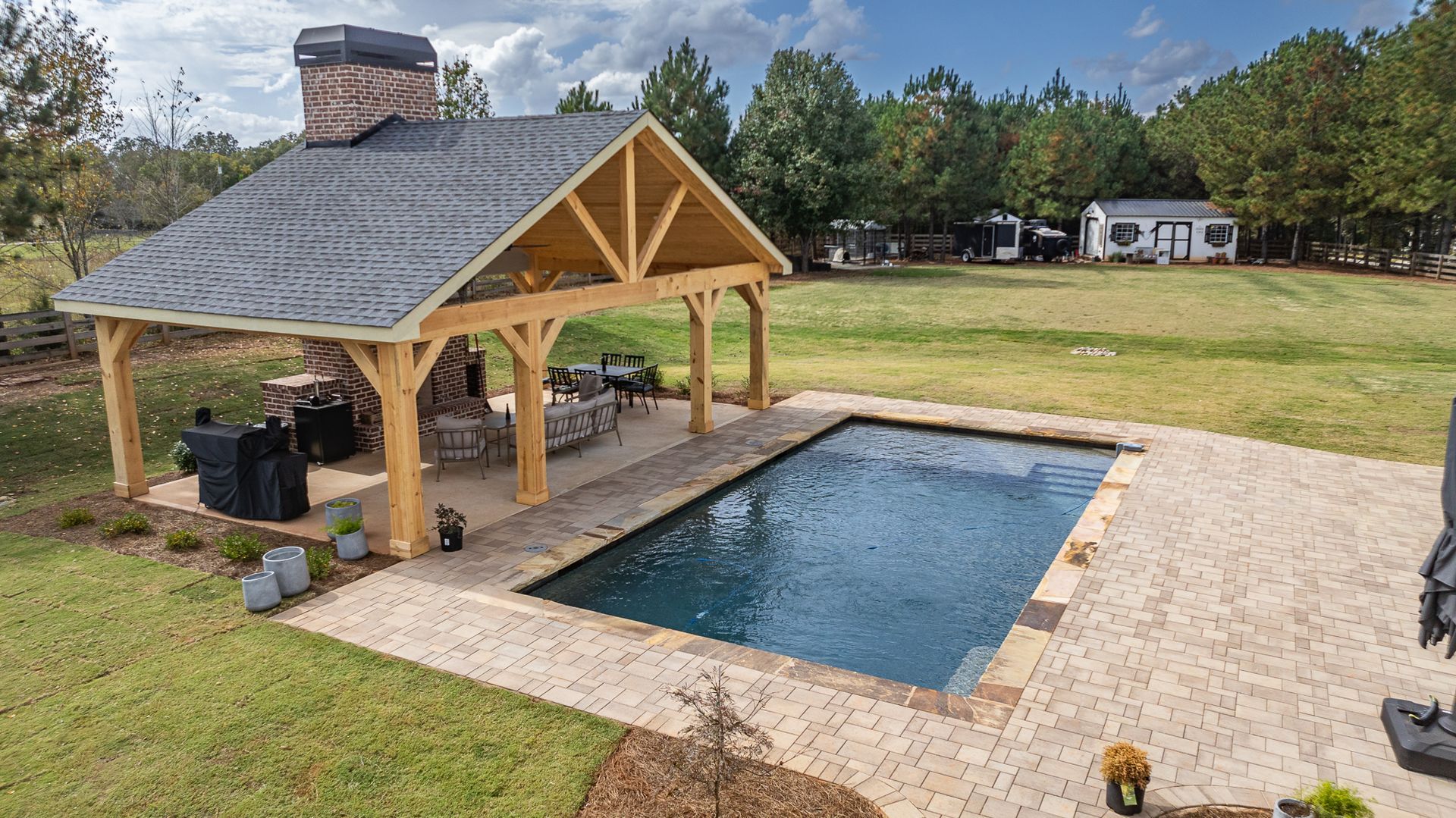 A large swimming pool with a pavilion in the backyard.