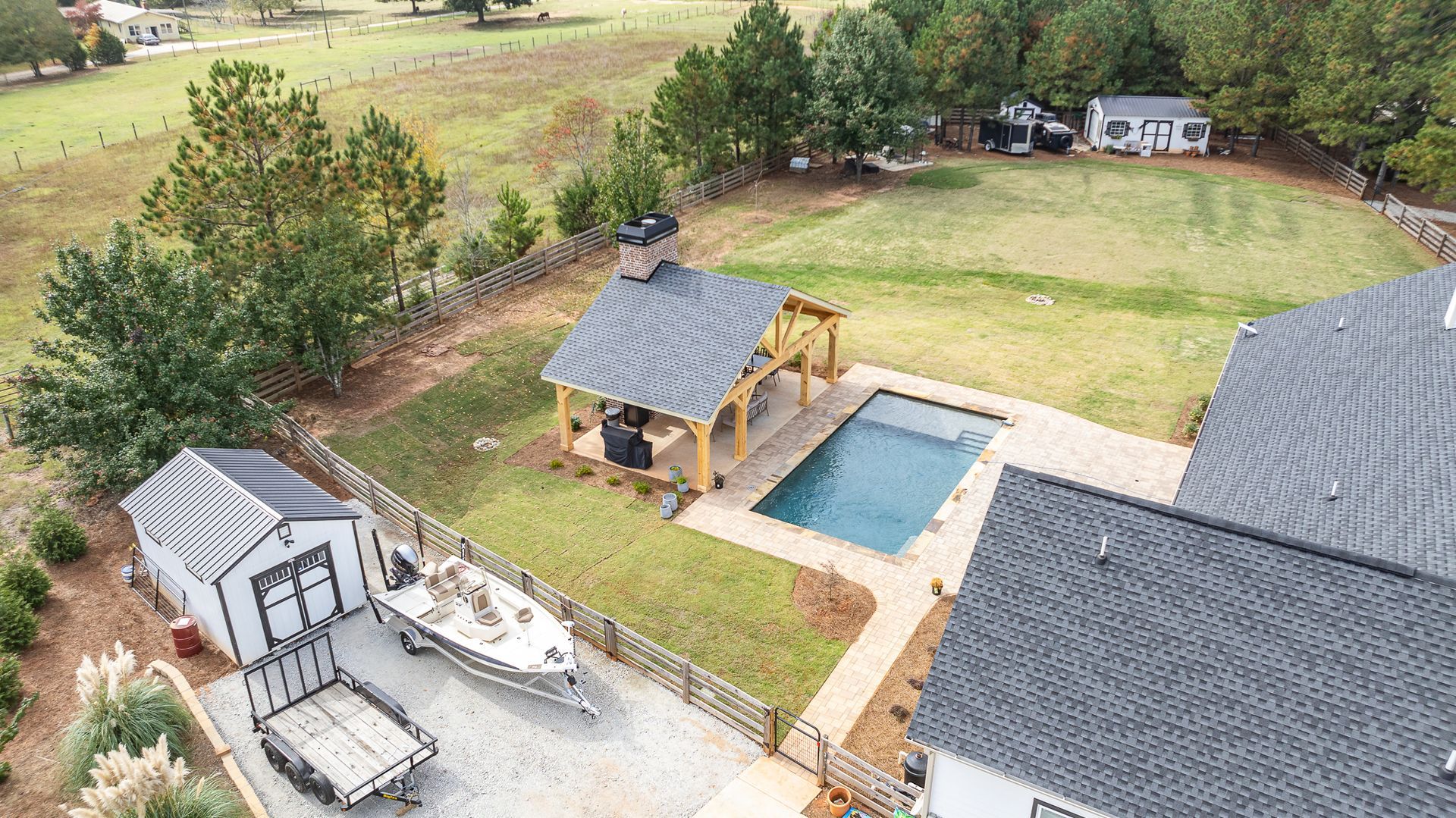 An aerial view of a house with a pool and a boat in the backyard.