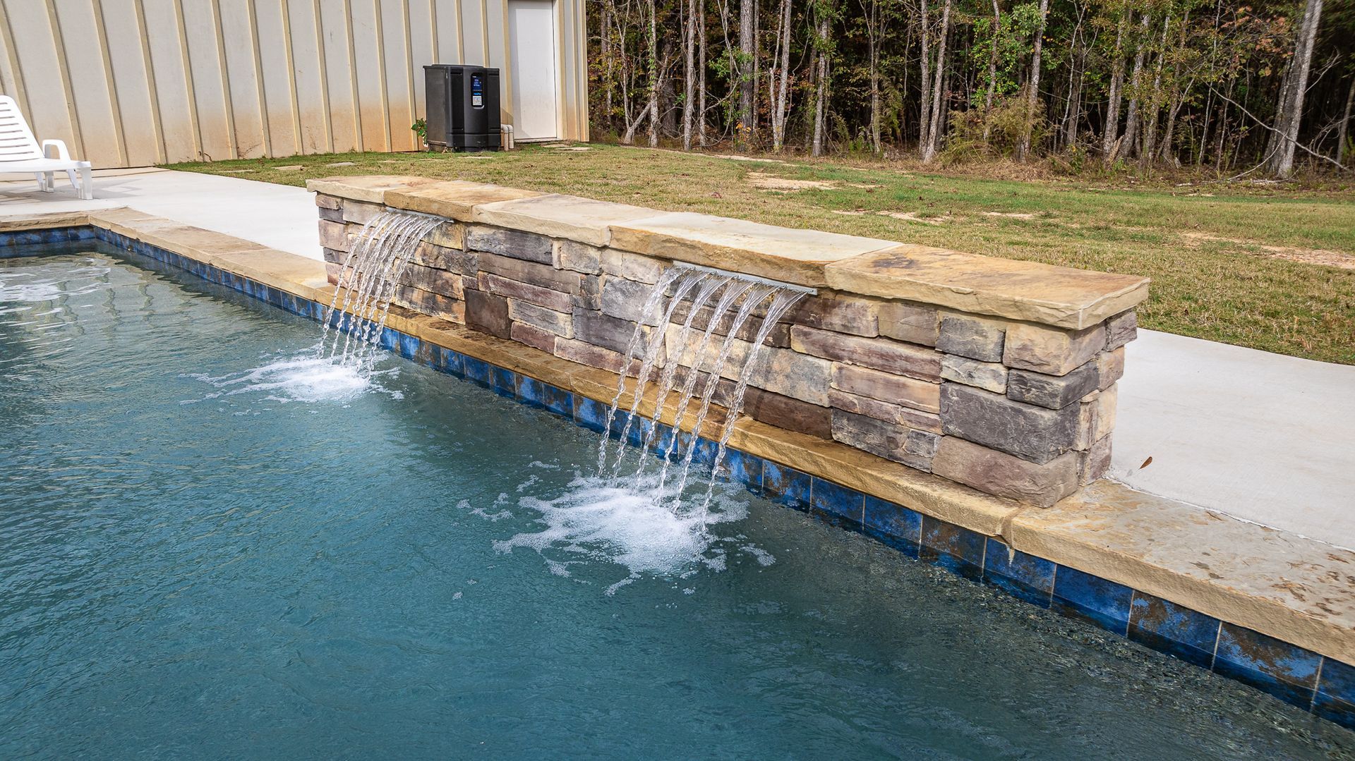 There is a waterfall in the middle of the pool.