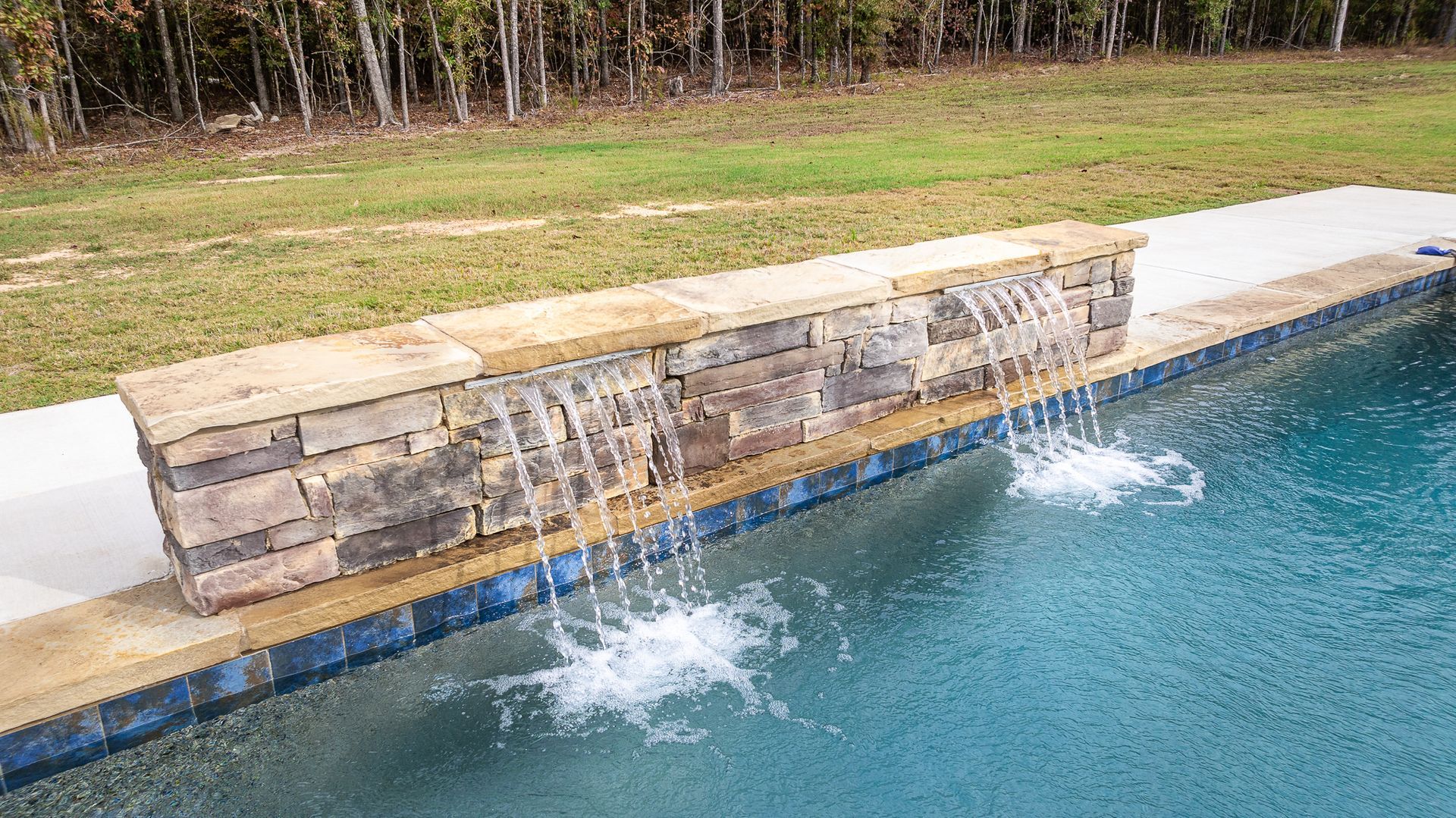 There is a waterfall in the middle of the pool.