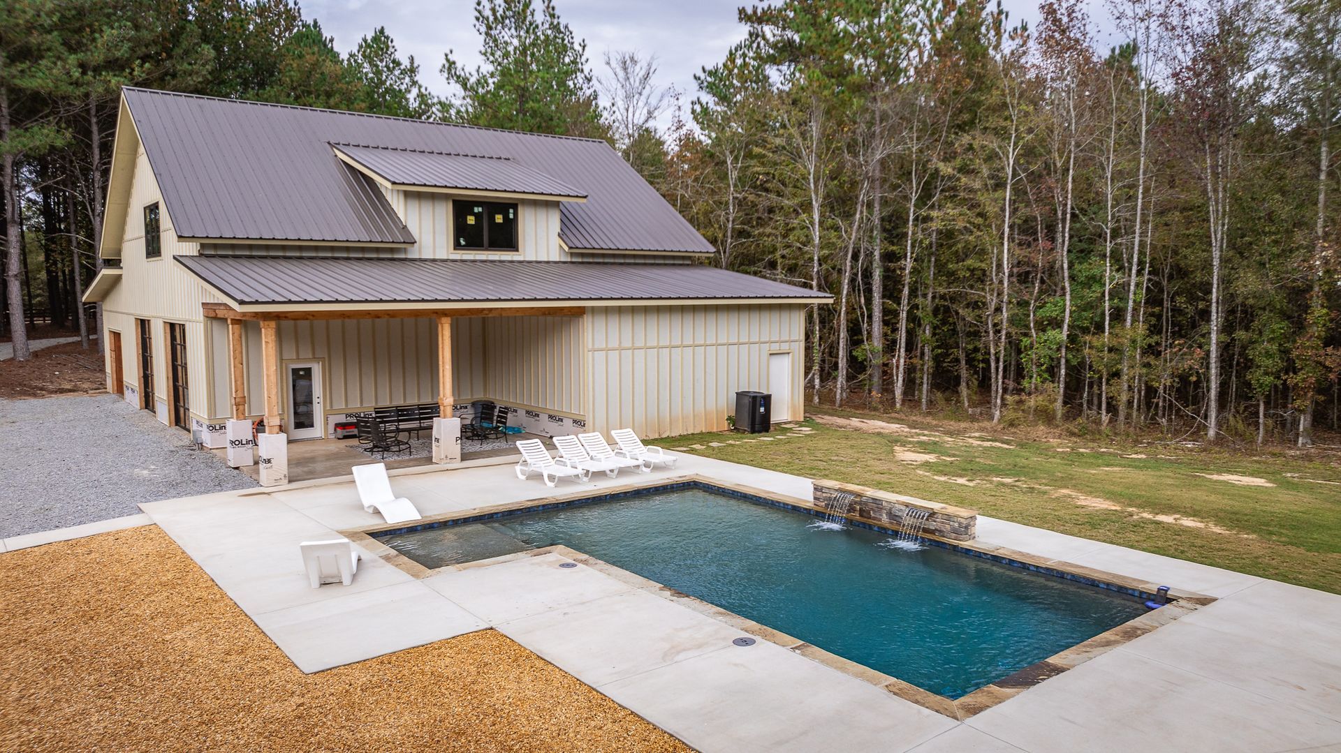 A house with a large swimming pool in front of it.