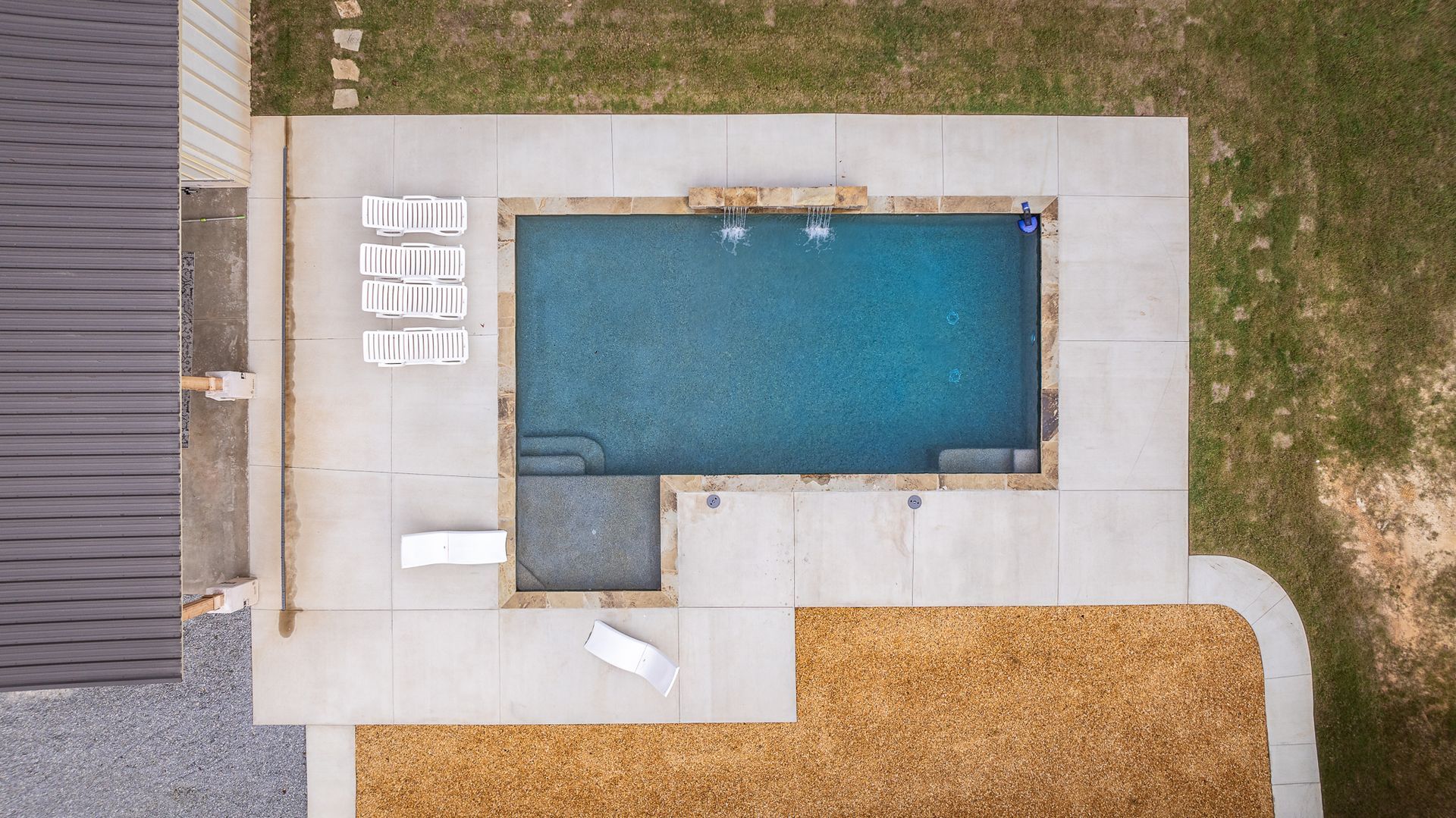An aerial view of a large swimming pool in a backyard.