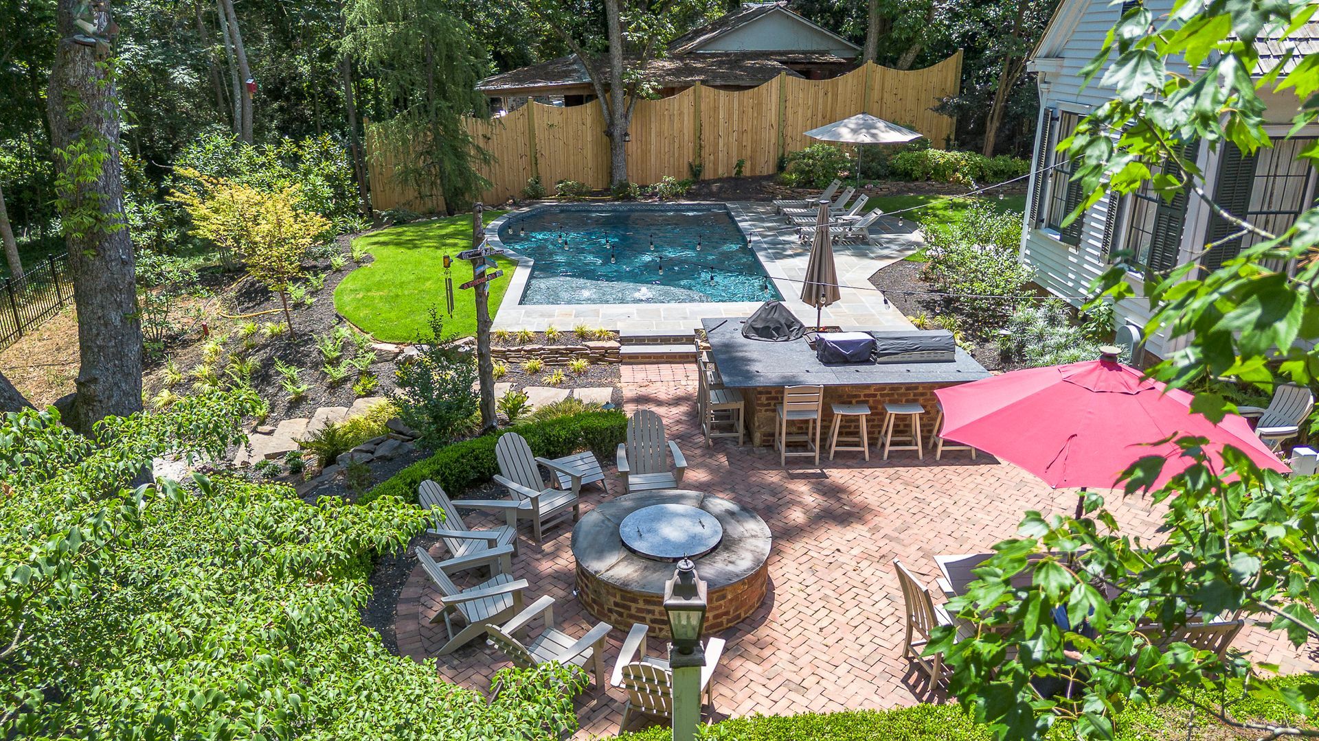 Backyard with pool, patio, fire pit, and outdoor bar.