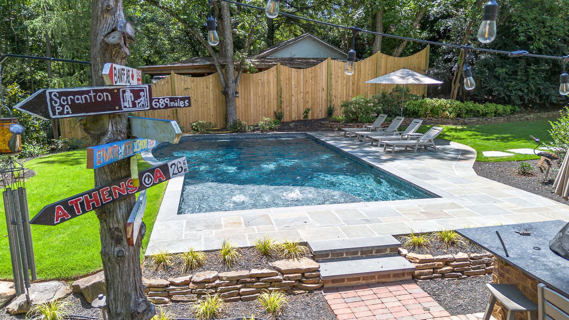 A large swimming pool in a backyard with signs pointing in different directions.