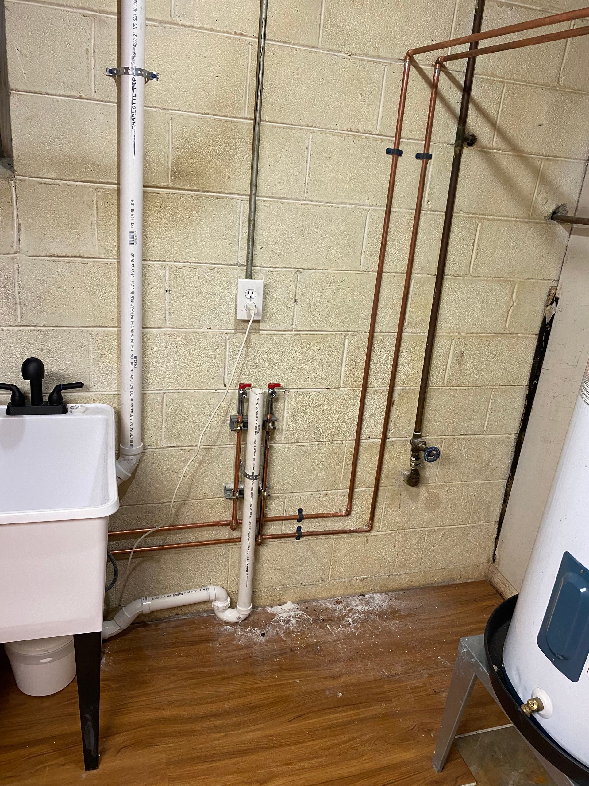 There is a sink and a water heater in the basement.