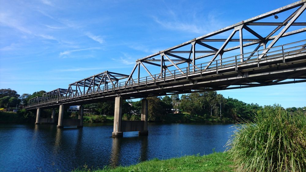 A Bridge Over a River with A Blue Sky in The Background — J’s Concreting & Carpentry in Kempsey, NSW