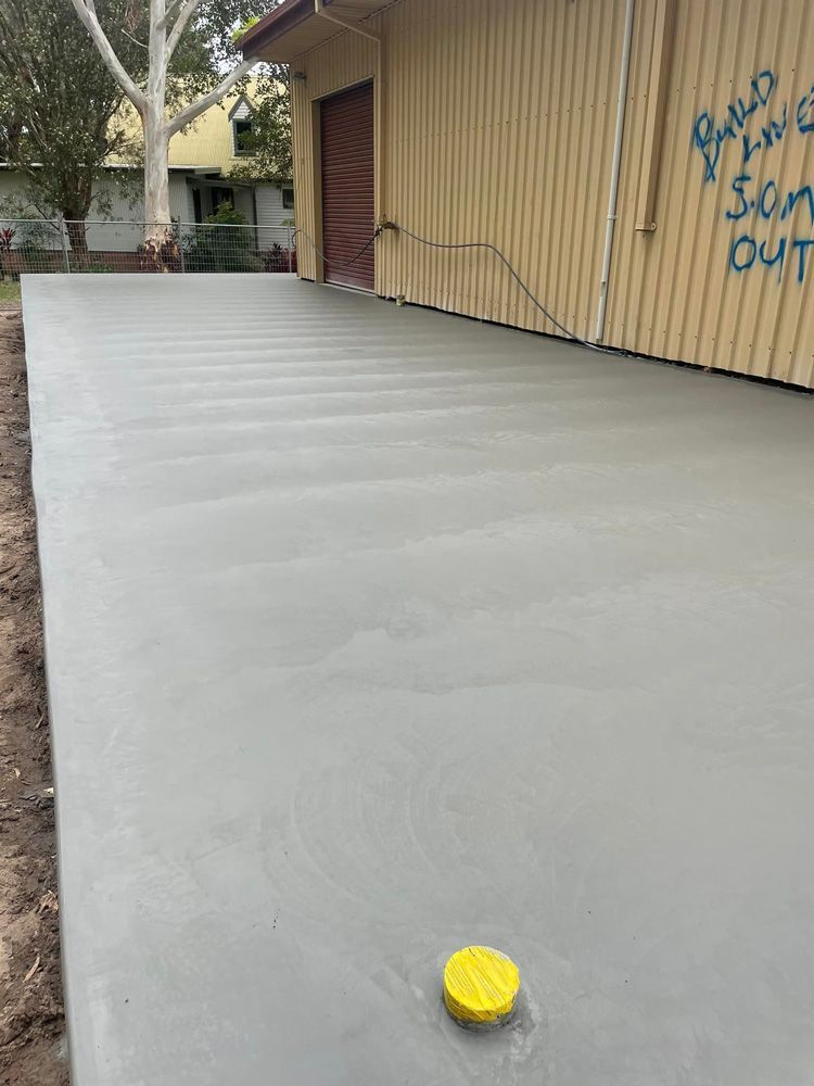 A Concrete Driveway Is Being Built in Front of A Building — J’s Concreting & Carpentry in Kendall, NSW