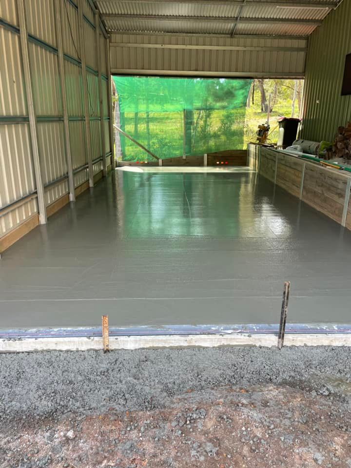 A Concrete Floor Is Being Installed in A Garage — J’s Concreting & Carpentry in Kew, NSW