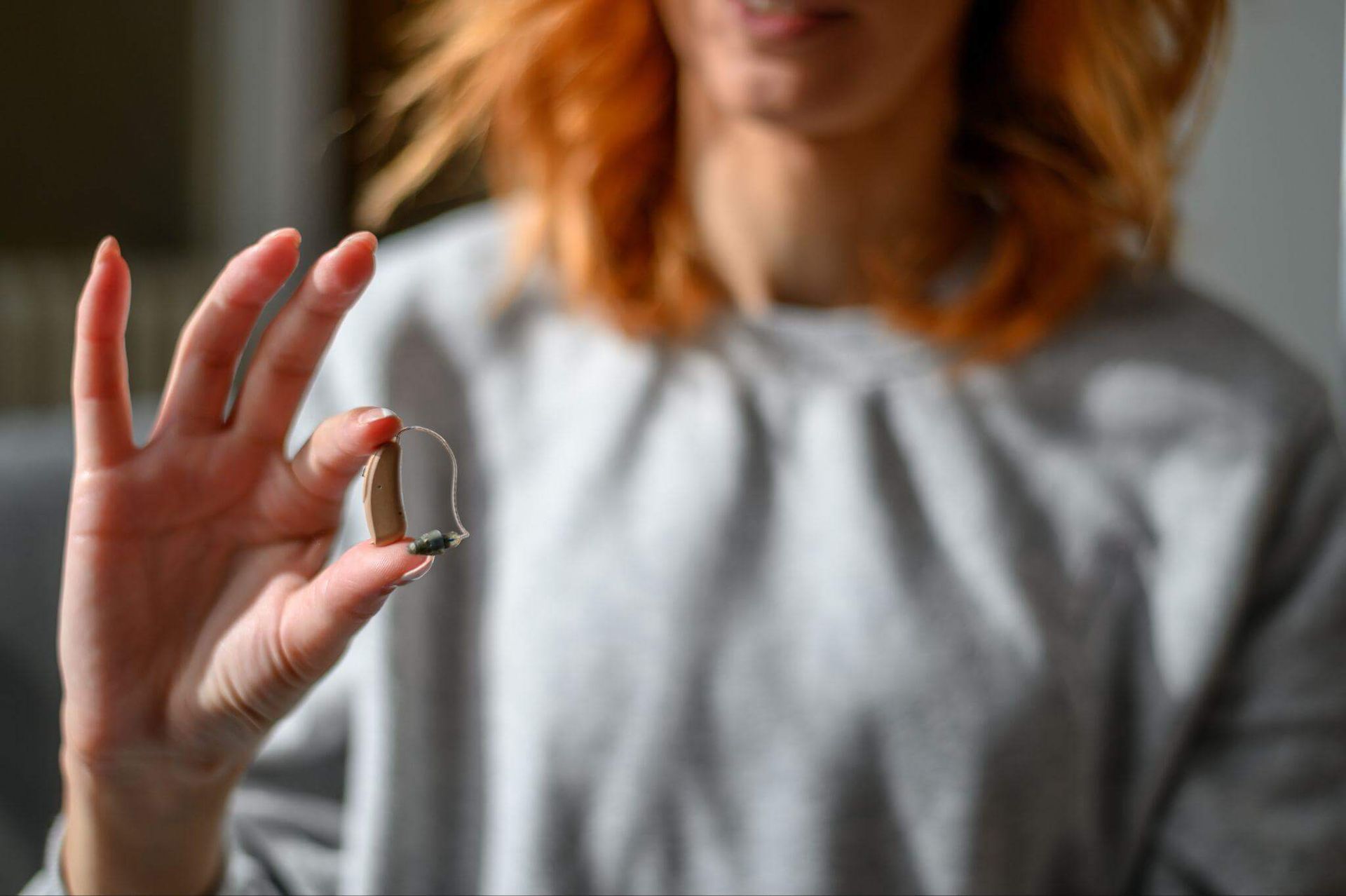 woman holing a hearing aid