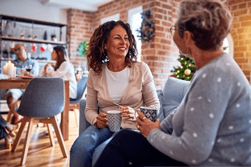 older woman conversing with a friend in a cafe