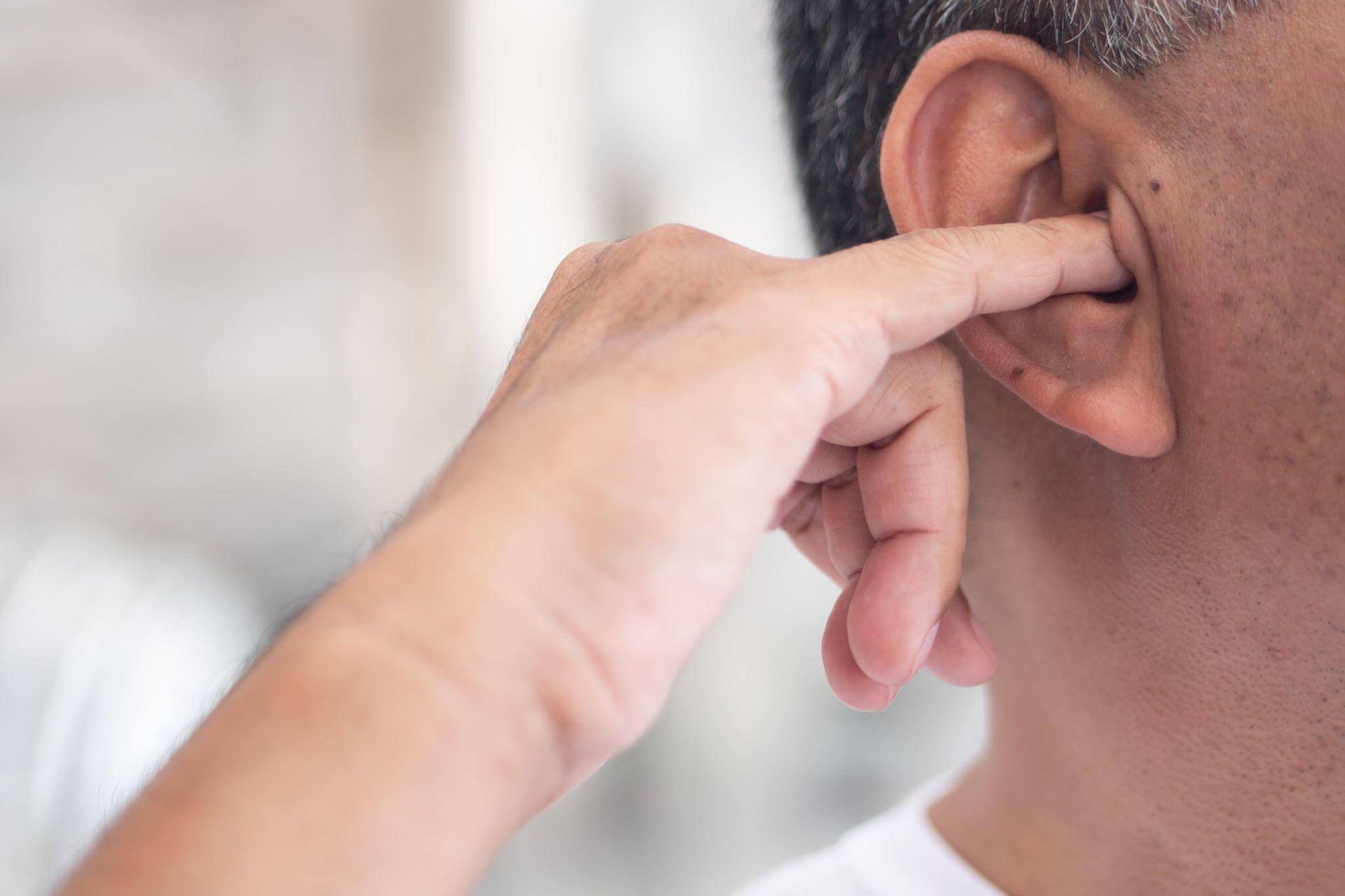 man attempting to clear ear wax with his finger