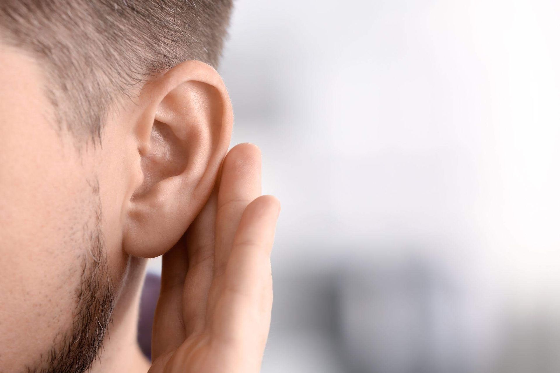 man with hearing loss cupping his ear