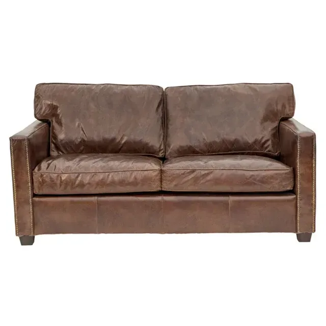 A brown leather couch is sitting on a white background.