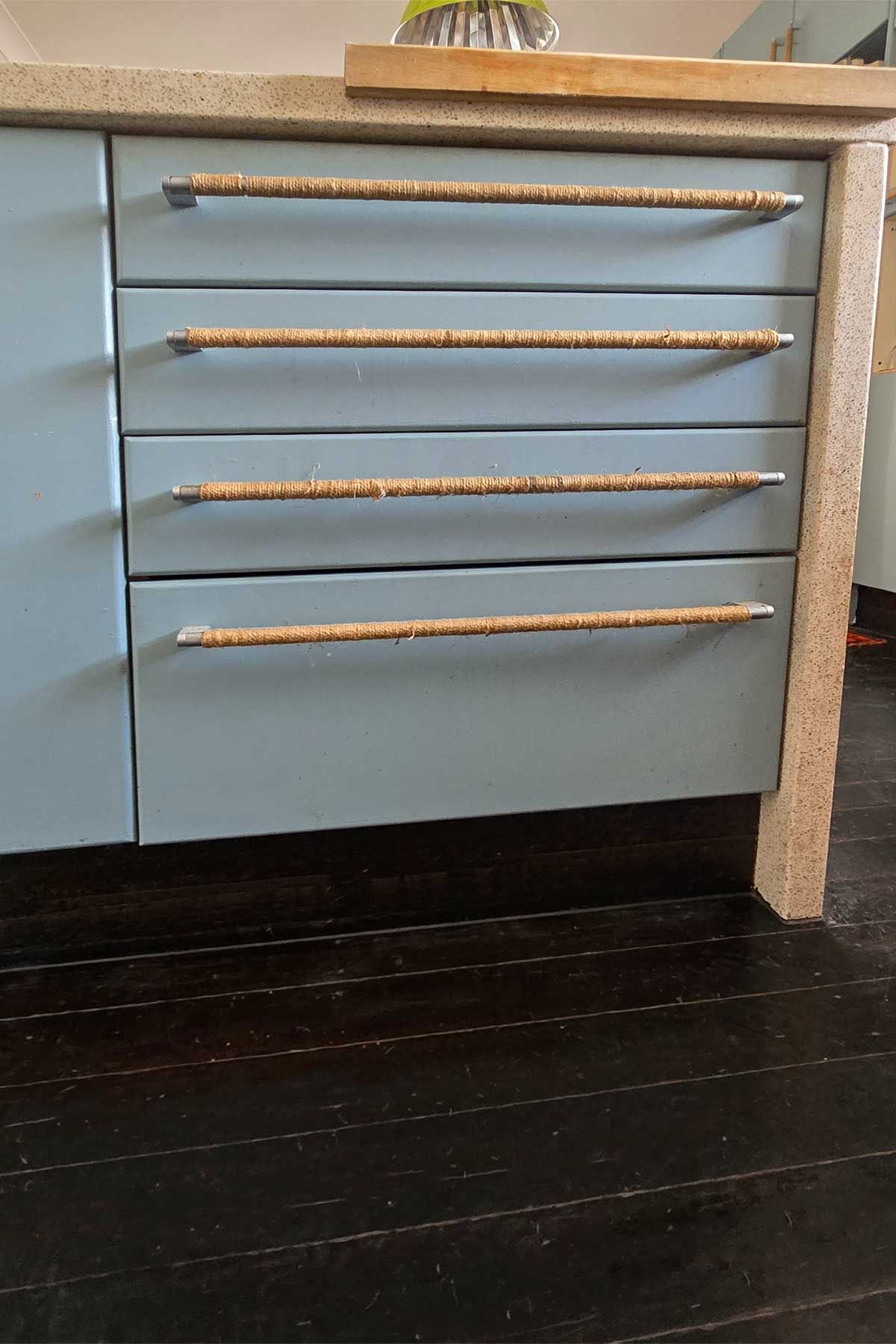 A kitchen with blue cabinets and wooden handles