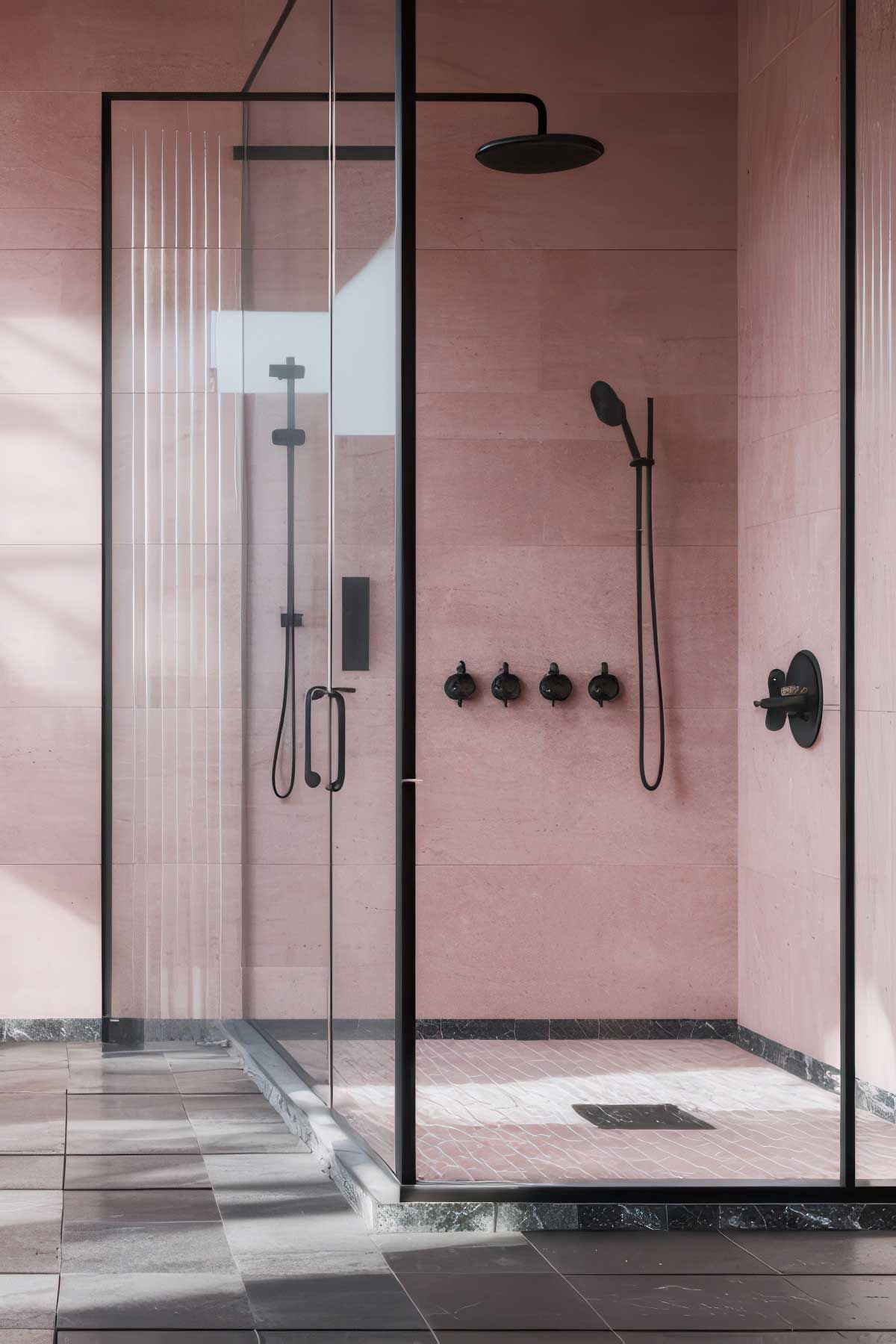 A shower with pink tiles and black shower head