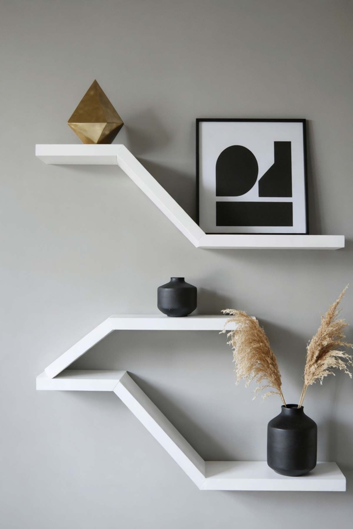 Three white shelves with vases and a picture on them