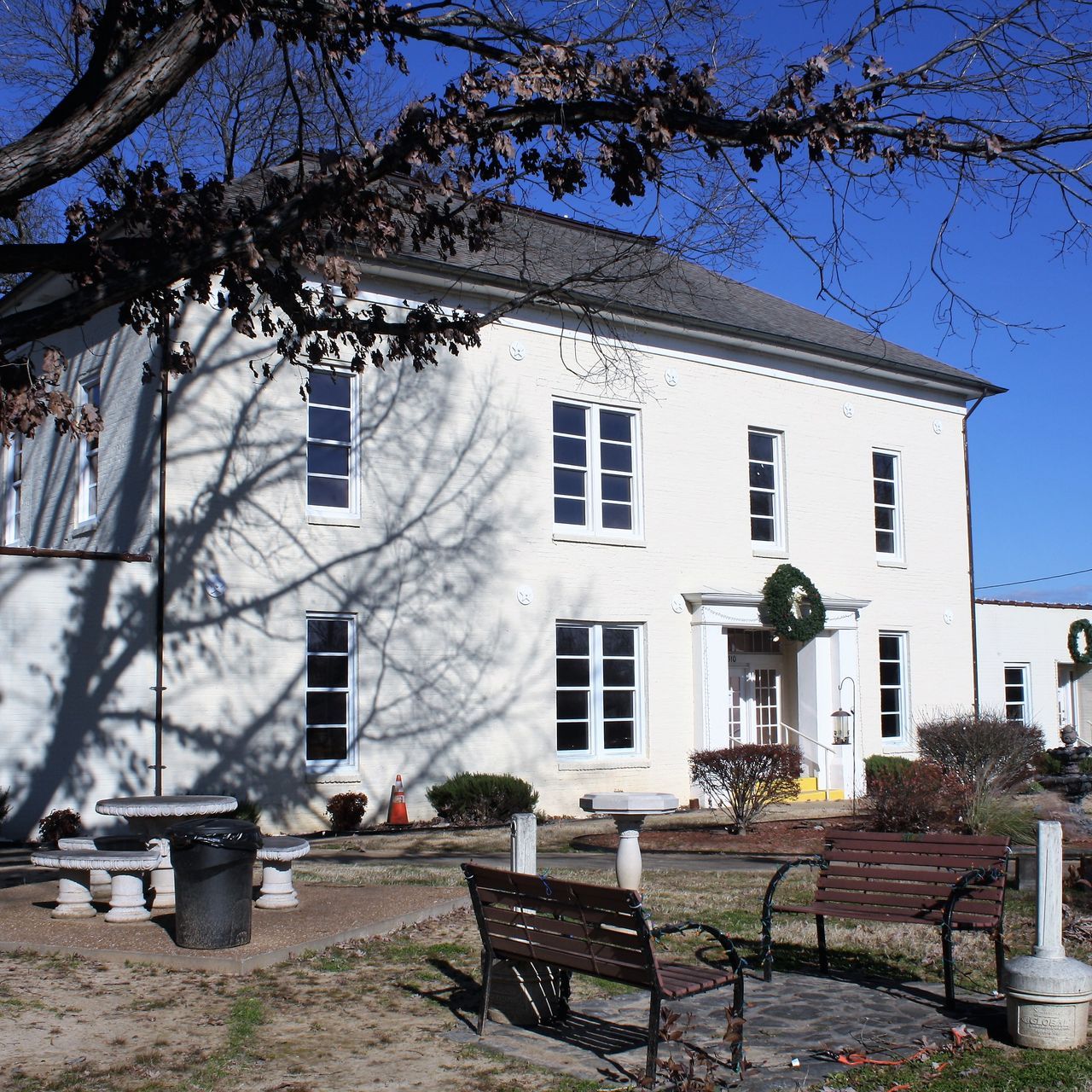 A large white house with a wreath on the front door