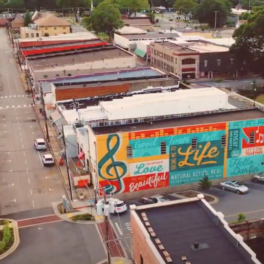 An aerial view of a city with a mural on the side of a building that says life