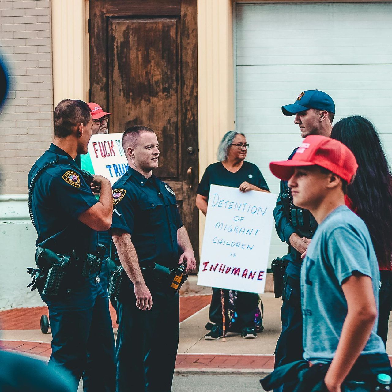 A group of people holding signs one of which says inhumane