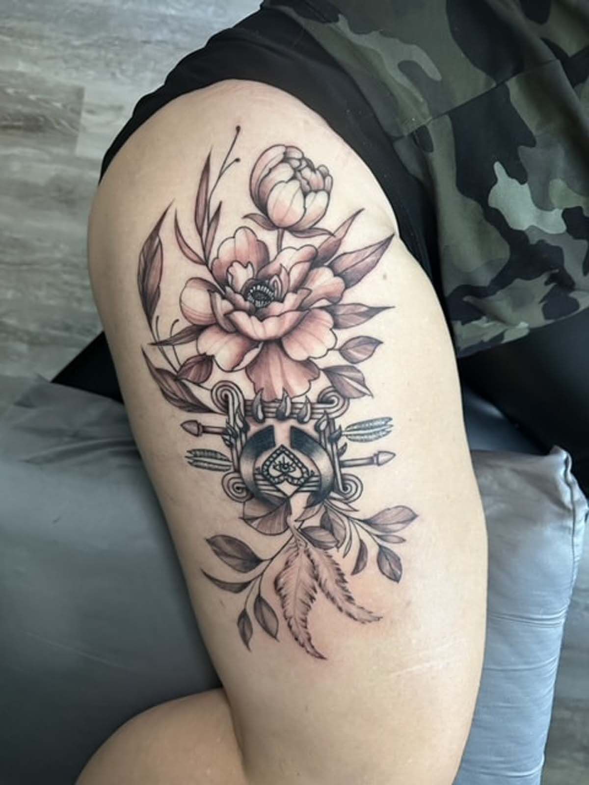 A woman has a tattoo of flowers on her thigh.