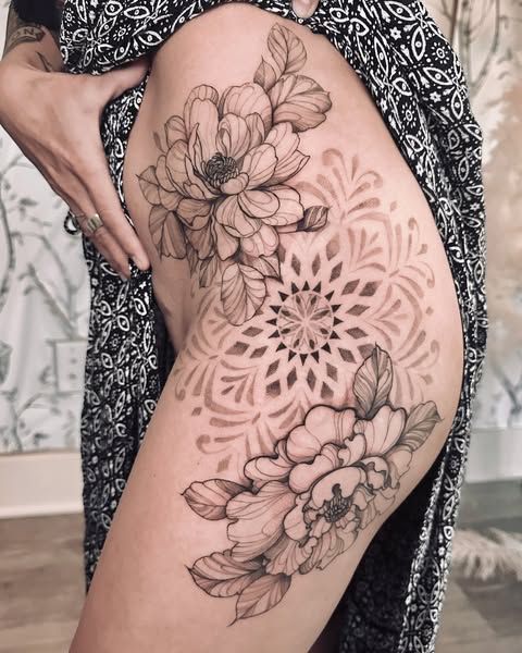 A woman has a tattoo of peony floral with a mandala