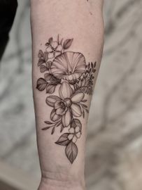 A woman has a tattoo of flowers on her forearm.