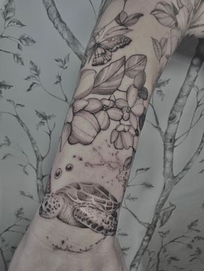 A woman has a tattoo of flowers on her forearm.