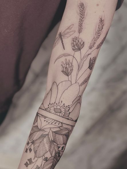 A woman has a tattoo of flowers on her thigh.