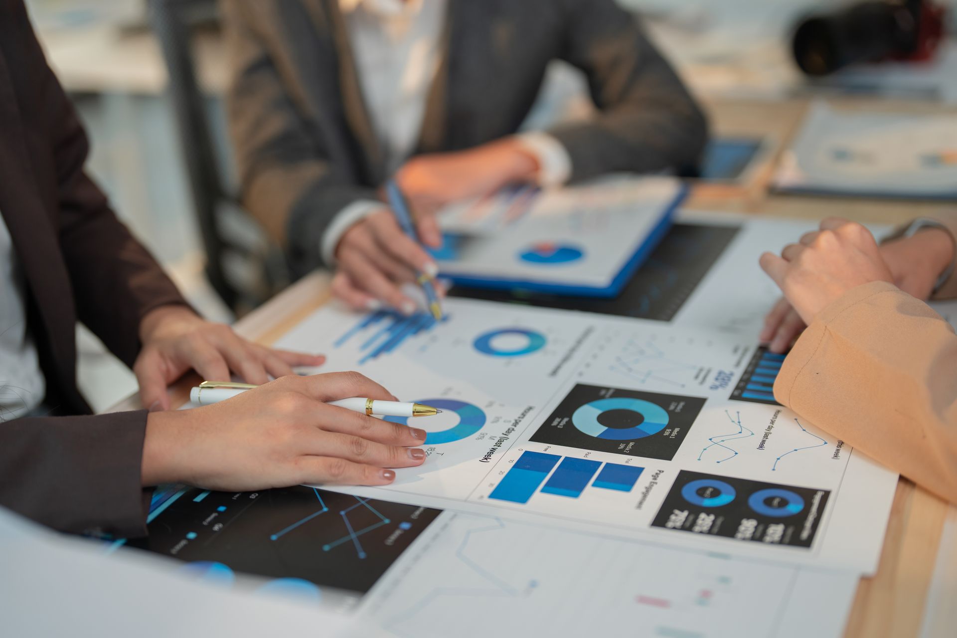 A group of people are sitting around a table looking at graphs.