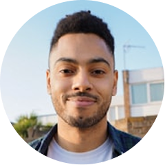 Portrait of a smiling person outdoors with a building in the background