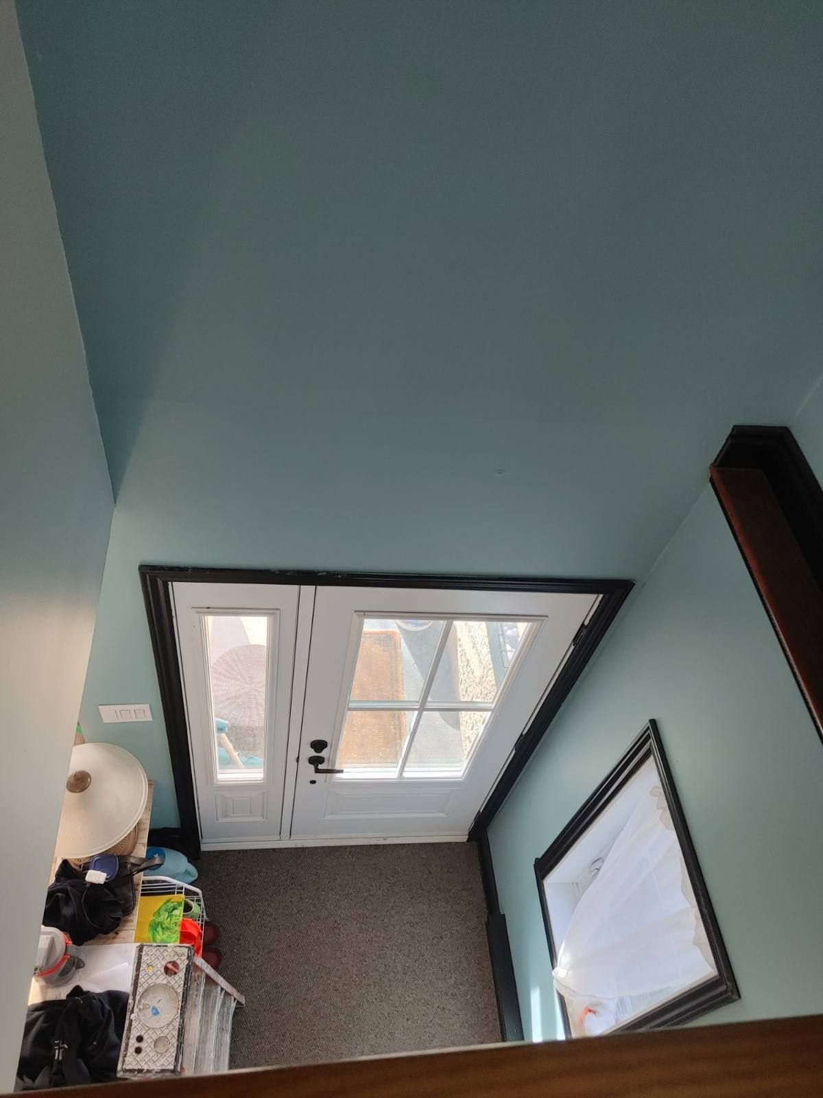 Vue aérienne d'une porte, murs bleus, boiseries marron.