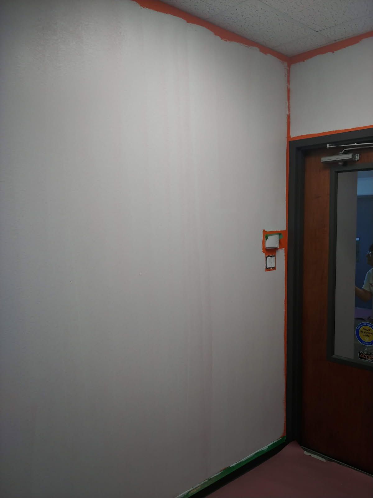 Mur blanc avec des moulures orange et un encadrement de porte.