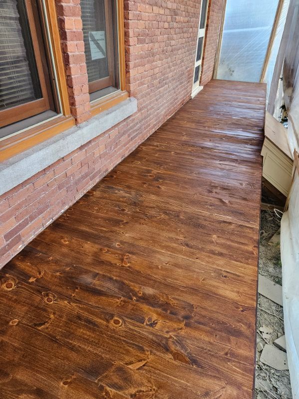 Rampe en bois teintée foncée à côté d'un bâtiment en briques.