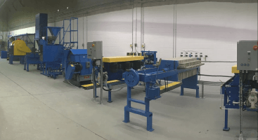 a row of blue and yellow machinery in a factory .