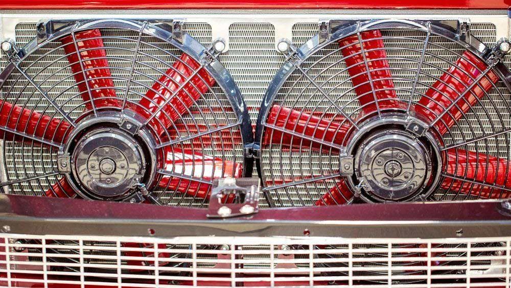 A Close-up Of a Car Radiator with Two Red Fans on It — Al's Mechanical & 4WD Grafton Repairs in Grafton, NSW