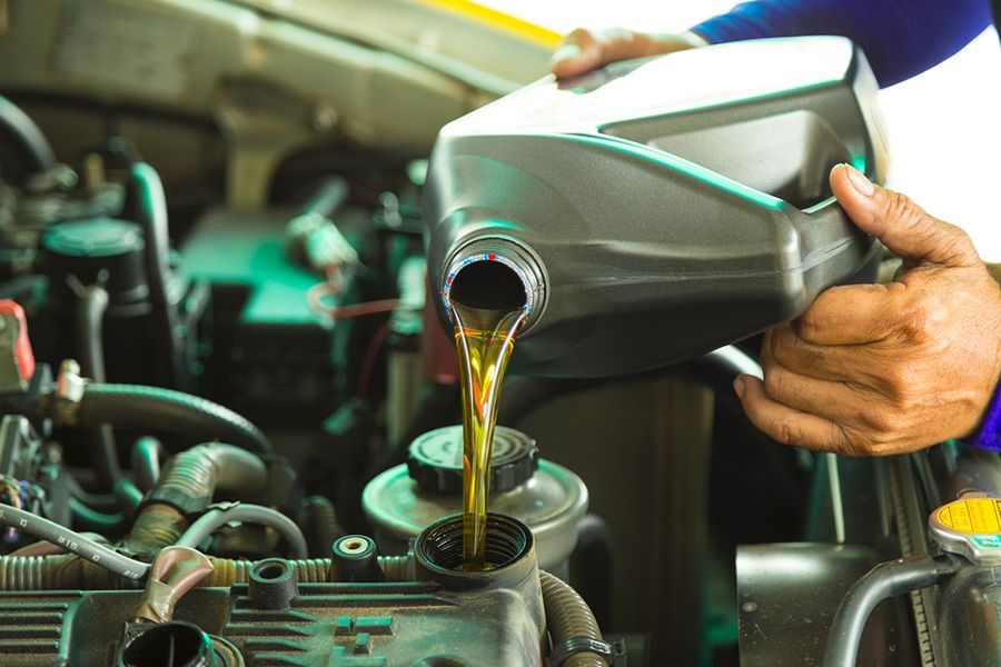 A Person Is Pouring Oil Into a Car Engine — Al's Mechanical & 4WD Grafton Repairs in Grafton, NSW