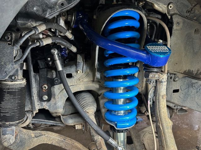 A Close -up Of a Car Suspension with A Tire in The Background — Al's Mechanical & 4WD Grafton Repairs in Grafton, NSW