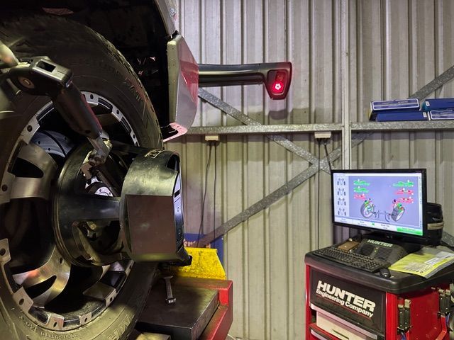 A Red Car Is Sitting on A Lift in A Garage — Al's Mechanical & 4WD Grafton Repairs in Grafton, NSW