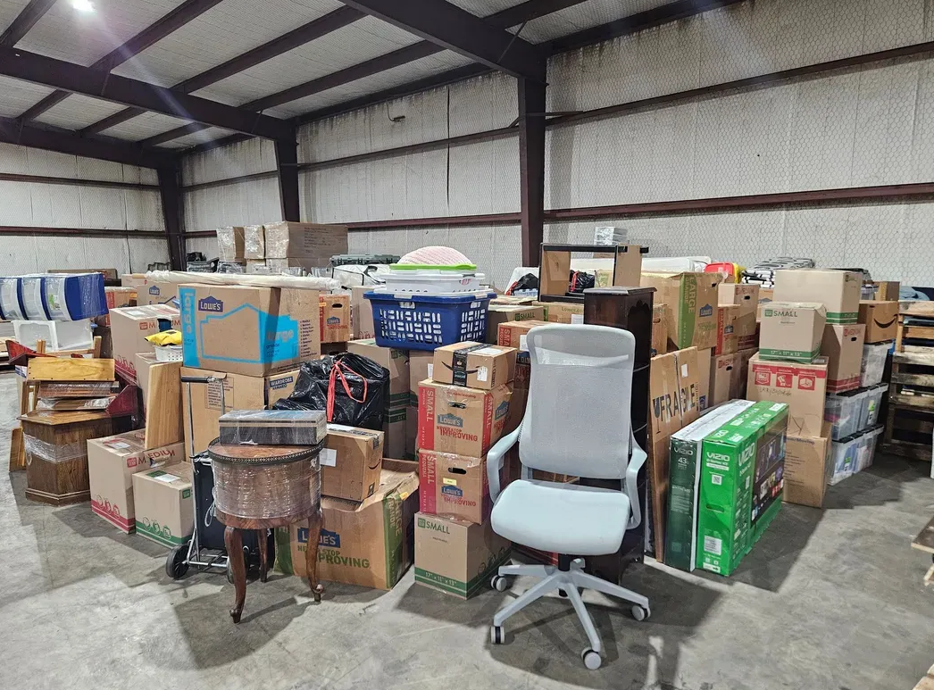 A warehouse filled with lots of boxes and a chair.