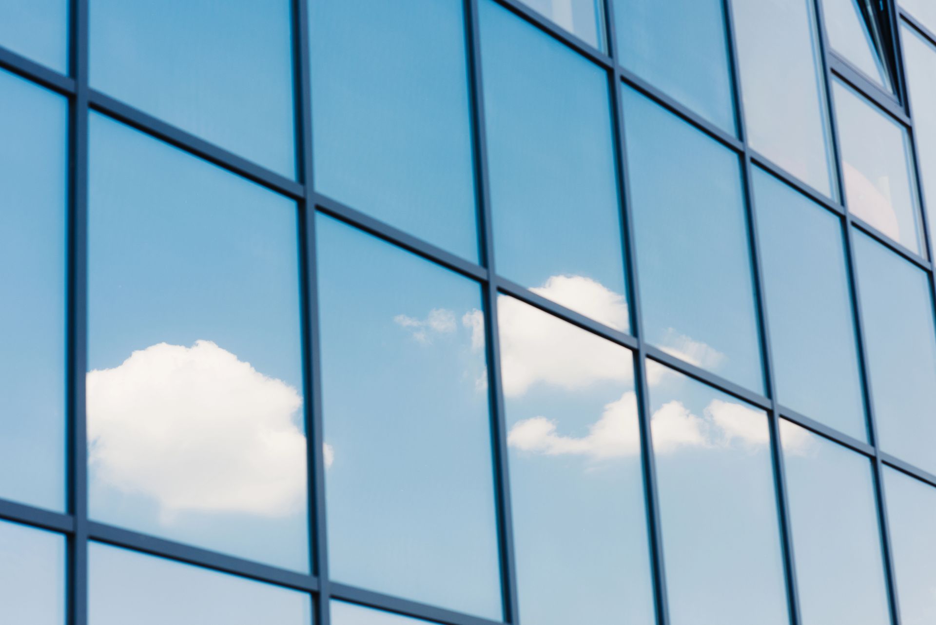 Las nubes se reflejan en las ventanas de un edificio.