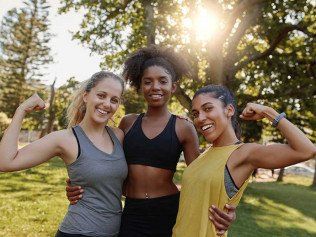 three girls jogging and flexing in athletic attire