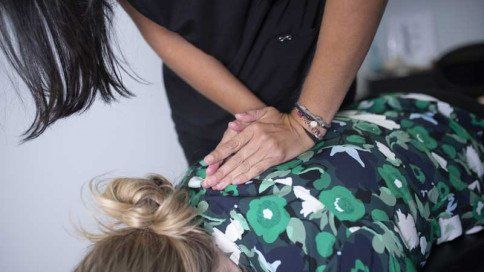 a woman is giving a woman a massage on her back .