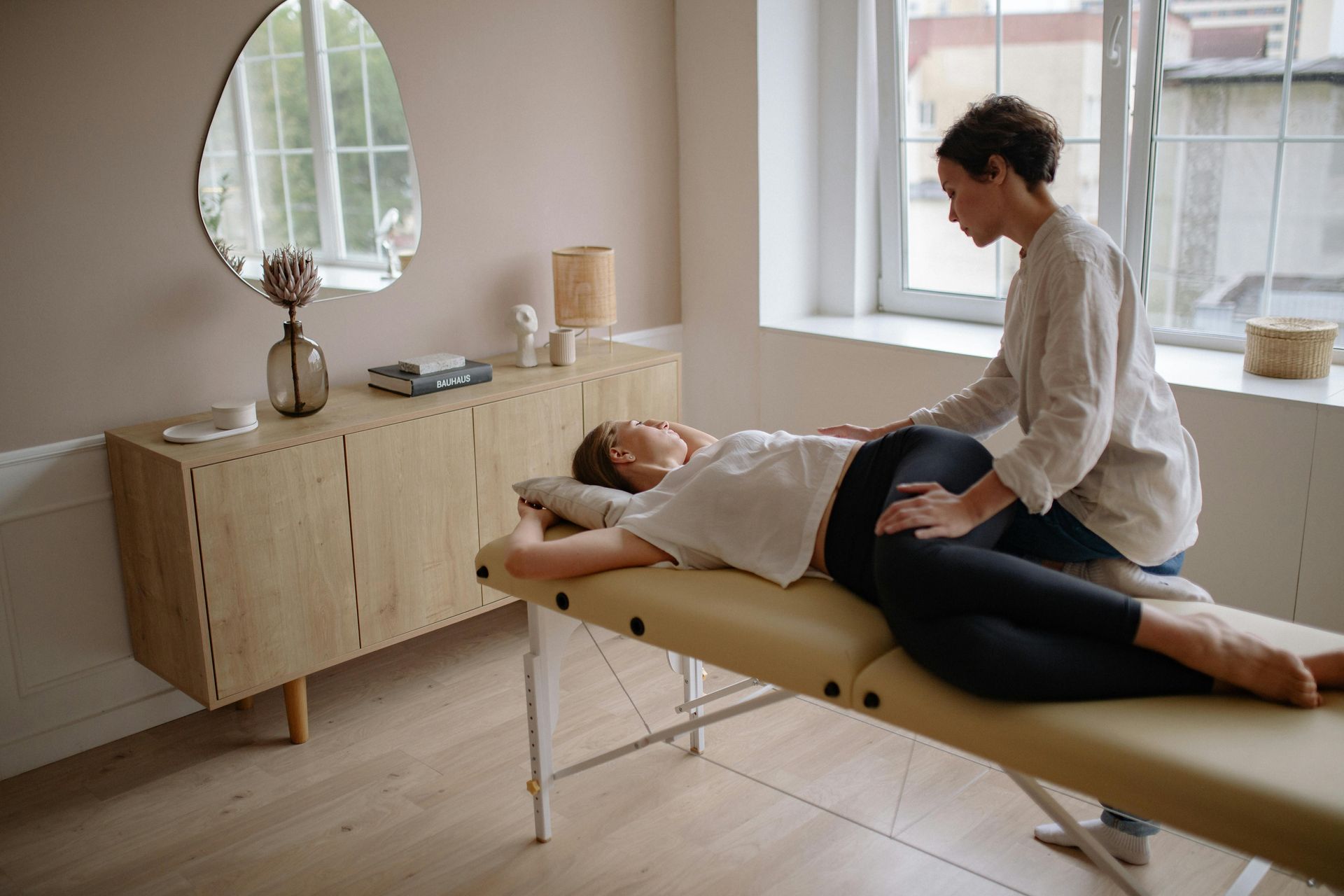 A woman is laying on a table getting a chiropractic adjustment from a doctor.