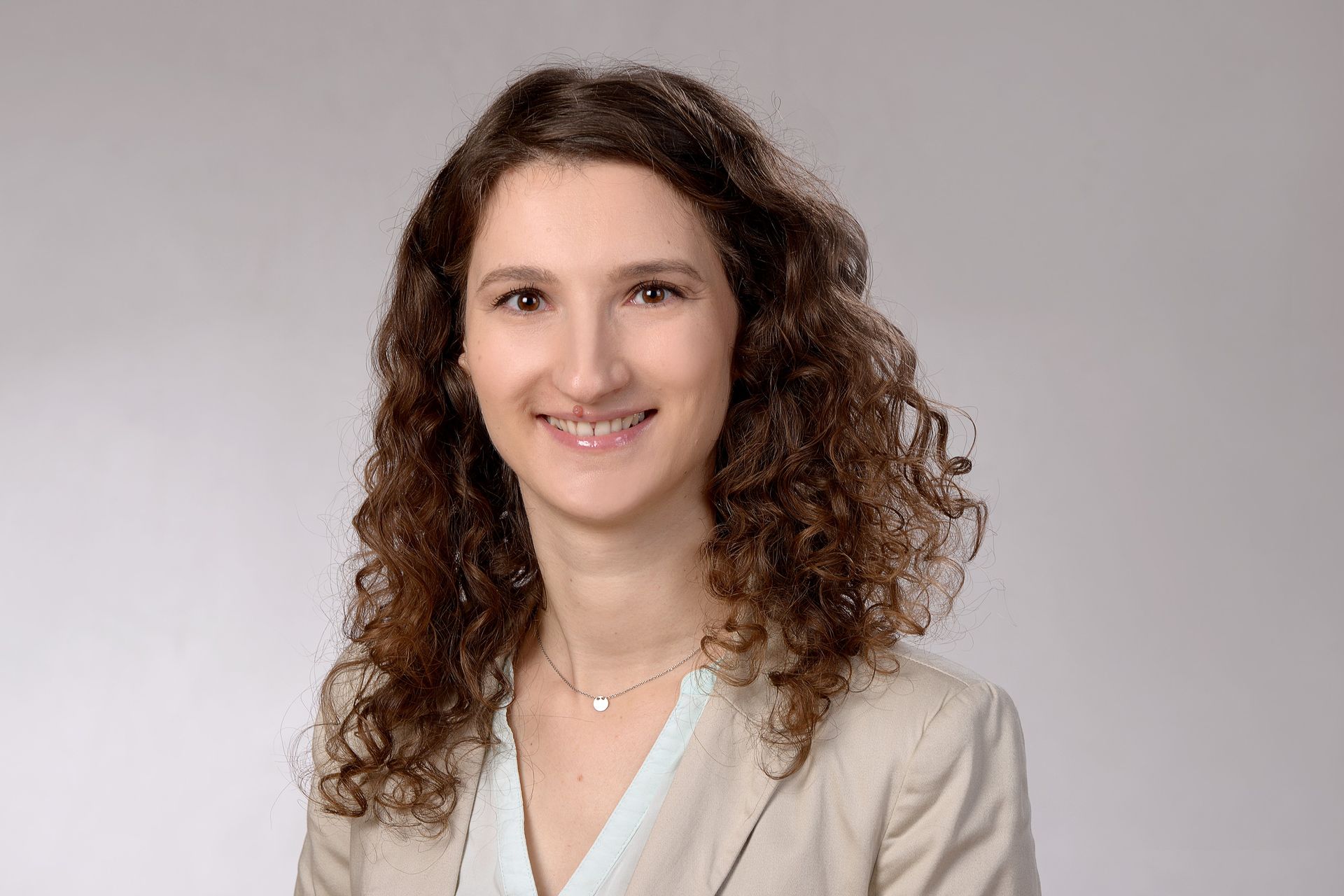 Eine Frau lächelt freundliche in die Kamera.