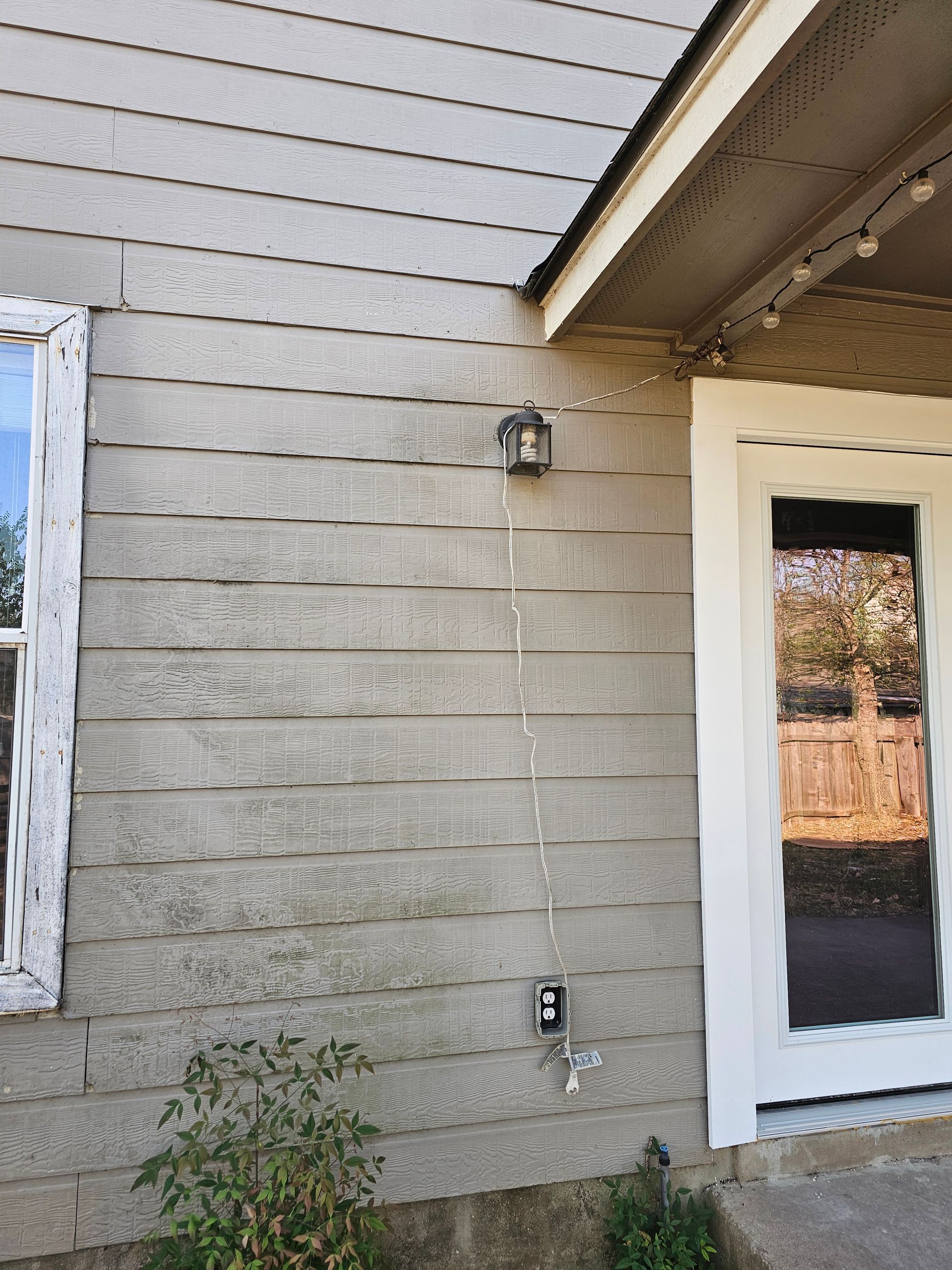 A house with a white door and a light on the side of it.