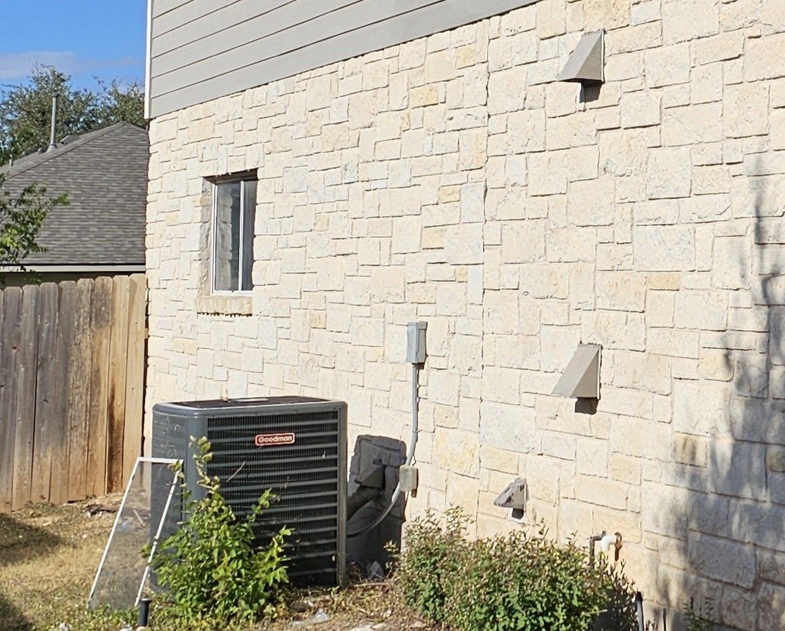 A brick building with a window and an air conditioner