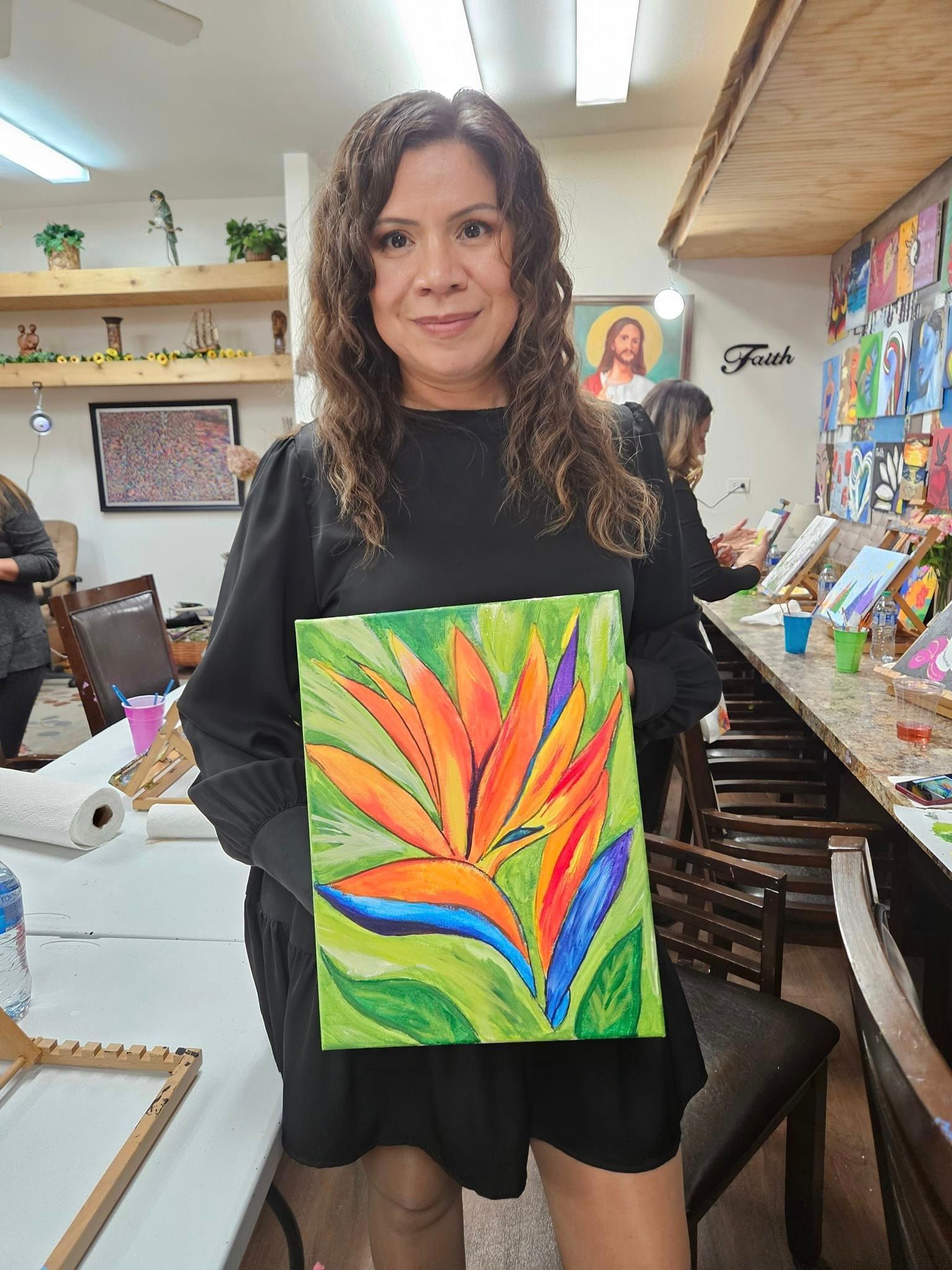 A woman is holding a painting of a bird of paradise flower.