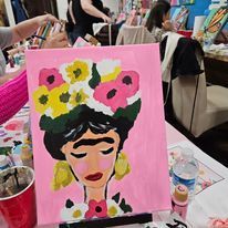 A painting of a woman with flowers in her hair is sitting on a table.