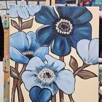 A close up of a painting of blue flowers on a canvas on an easel.